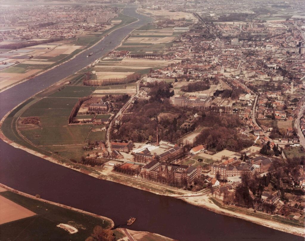 Luchtfoto van het kloosterdorp Steyl in 1979, genomen in de noordelijke richting, met o.a. de Maas; veerpont Baarlo-Steyl; op de voorgrond: het Missiehuis van de paters SVD, links in het Maasveld: het klooster van de 